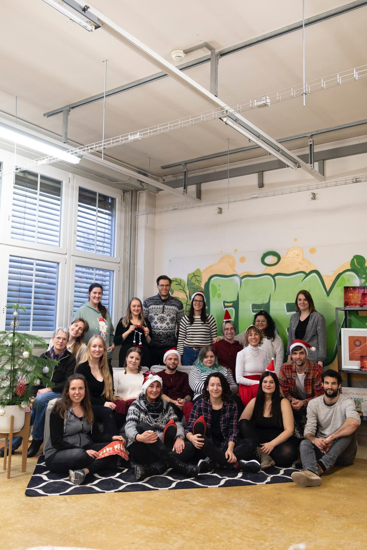 Die feeymily mit Weihnachtshüten vor der feey-Wand.