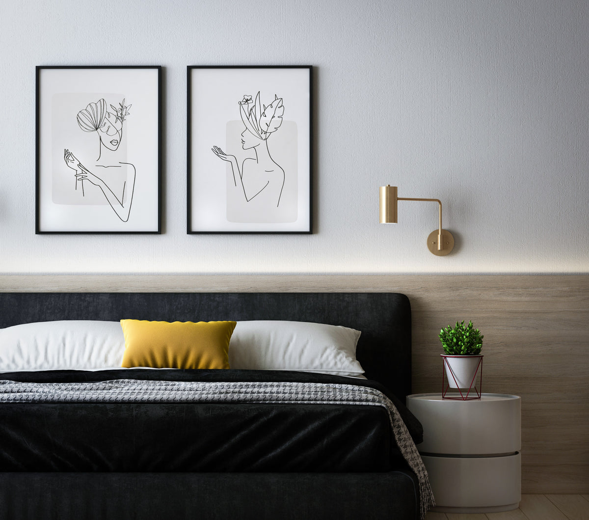 Auf einem schwarzen Bett hat es weisse und ein gelbes Kissen. An der Wand hängen zwei Bilder mit One-Line-Kunst. An der Wand hat es eine goldene Lampe fixiert. Auf einem weissen runden Nachttisch steht eine kleine Pflanze in einem weissen Topf.