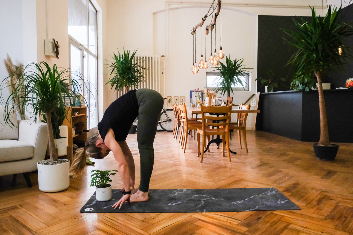 Plant-Yogi Hanna steht mit gestreckten Beinen und vornübergebeugtem Oberkörper da